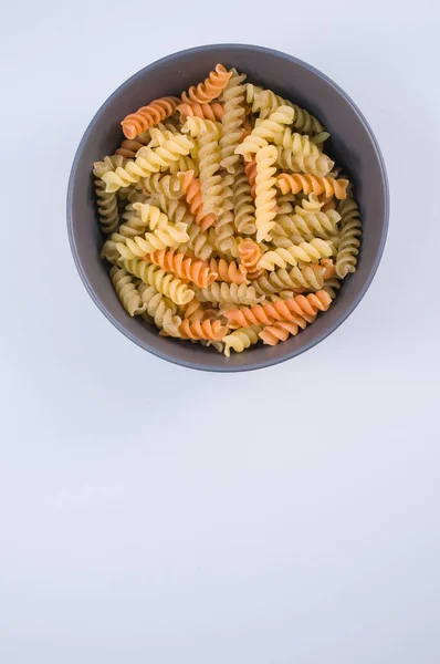 Una Toma Vertical Pasta Rotini Tricolor Tazón Aislado Sobre Fondo — Foto de Stock