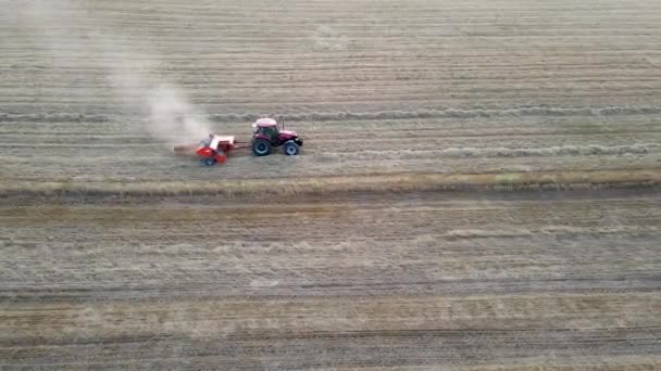 Belo tiro de uma máquina de colheita em um campo de trigo com um céu azul claro no fundo — Vídeo de Stock