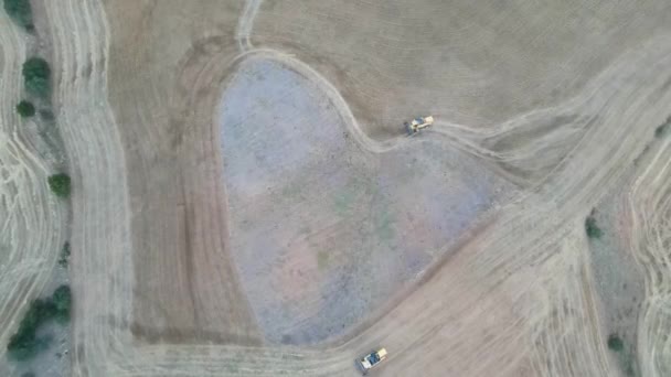 Mooie opname van een oogstmachine in een tarweveld met een helderblauwe lucht op de achtergrond — Stockvideo