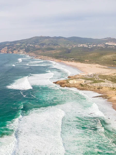 暖かい晴れた日に海の波がそれにクラッシュする美しいGuinchoビーチの垂直ショット — ストック写真