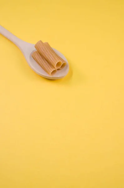 Sebuah Gambar Vertikal Rigatoni Pada Sendok Pada Permukaan Kuning Dengan — Stok Foto