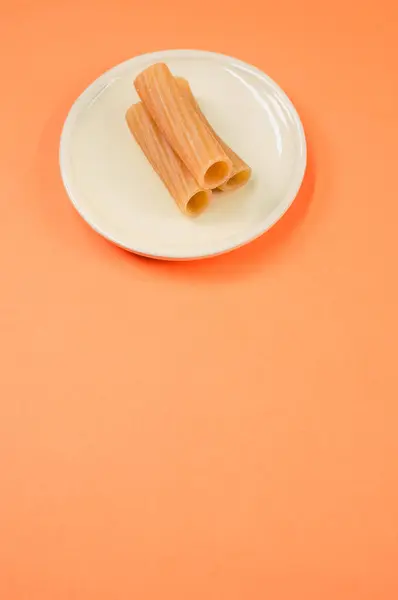 Sebuah Gambar Vertikal Rigatoni Pada Piring Putih Kecil Pada Permukaan — Stok Foto