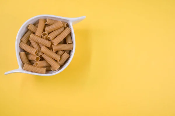 Tiro Vista Superior Rigatoni Uma Tigela Branca Uma Superfície Amarela — Fotografia de Stock