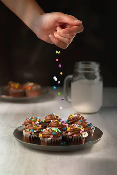 Вертикальний Знімок Руки Прикрашає Шоколадні Кекси Морозивом Різнокольоровими Зморшками — стокове фото