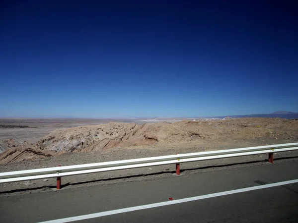 Una Strada Circondata Recinzioni Una Zona Deserta Sotto Cielo Blu — Foto Stock