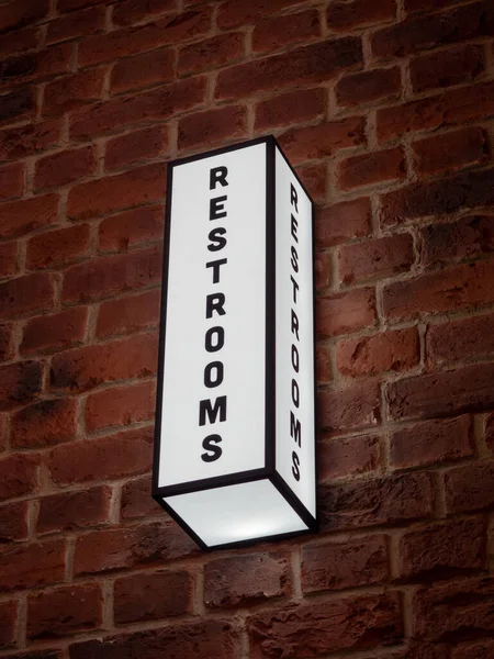 壁に白いLedライトが付いた長方形の Resrooms サインの垂直ショット — ストック写真