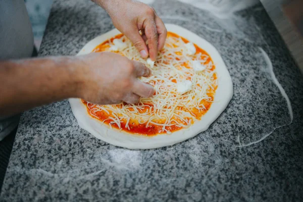 男人的手在柜台上做马格里塔披萨 — 图库照片
