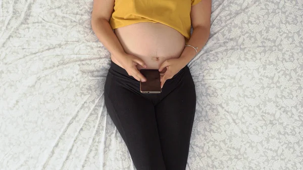 Vue Aérienne Une Femelle Enceinte Allongée Intérieur Avec Son Smartphone — Photo