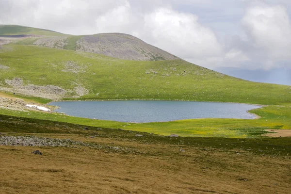 Poză Frumoasă Unui Lac Înconjurat Deal Verde Cer Tulbure Fundal — Fotografie, imagine de stoc