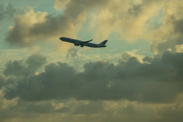 구름낀 하늘을 배경으로 비행기의 윤곽이 드러난다 — 스톡 사진