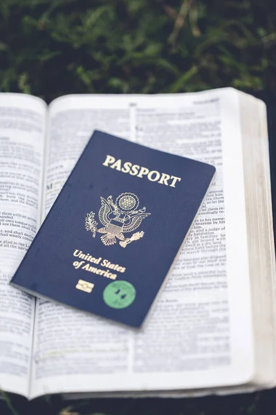 一本打开的圣经上的护照的垂直特写照片 — 图库照片