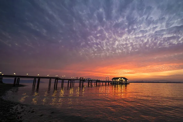 在海面上拍了一张美丽的落日的特写 在水面上拍了一张长长的甲板 — 图库照片