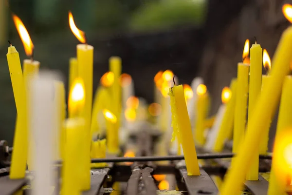 Eine Selektive Nahaufnahme Einer Verblassten Kerze Zwischen Vielen Brennenden Kerzen — Stockfoto