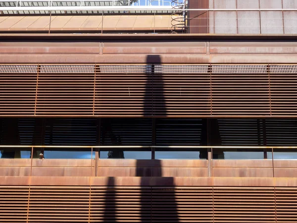 The balconies of a modern building with shadows on it on a sunny day