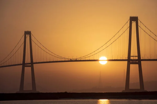 Vysoký Úhel Záběru Jasného Slunce Zapadajícího Velkým Mostem Přes Moře — Stock fotografie