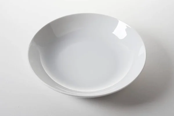 Ένα Λευκό Πιάτο Λείο Και Λαμπερό Σμάλτο Λευκό Φόντο — Φωτογραφία Αρχείου
