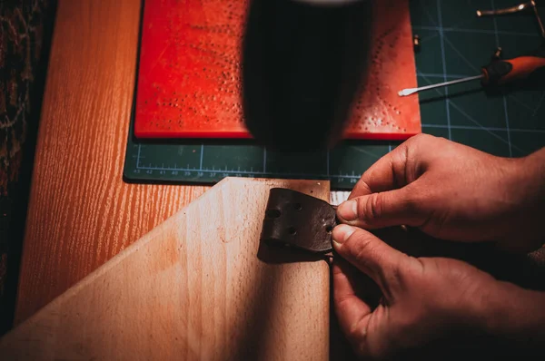 特写手的特写镜头 手握着木制表面的棕色皮带的折叠部分 — 图库照片