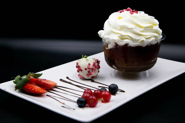 Ein Cupcake Auf Einem Weißen Teller Mit Beeren Auf Schwarzem — Stockfoto