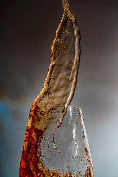 Närbild Skvätt Gyllene Vin Från Ett Glas Grå Bakgrund — Stockfoto