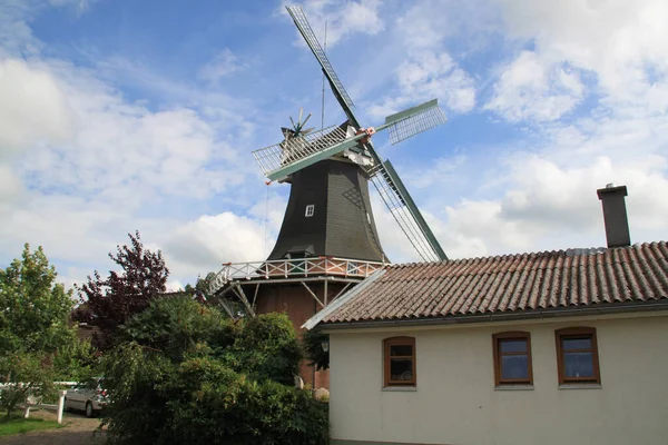 乡村的一座老式风车 周围是建筑物和绿地 — 图库照片