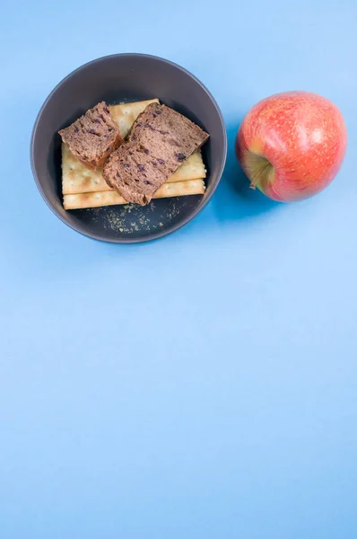 Closeup Tasty Crackers Slices Brown Bread Bowl Blue Surface — Stock Photo, Image