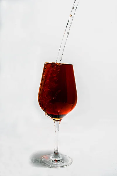 Agua Vertiendo Una Copa Vino Tinto Sobre Fondo Blanco —  Fotos de Stock