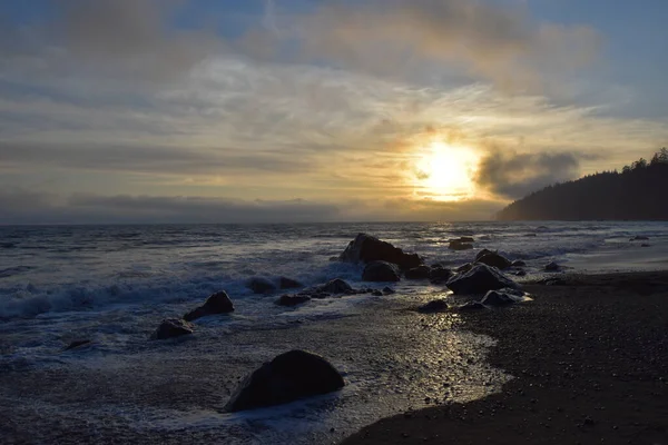 落日落在岩石的海滩上 — 图库照片
