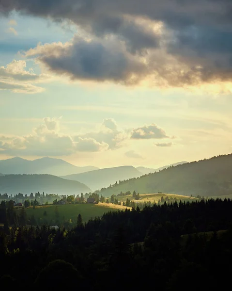 Pionowy Widok Wzgórz Pokrytych Lasami Pod Słońcem Zachmurzone Niebo Wsi — Zdjęcie stockowe