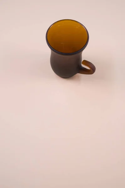 米黄色表面上的一个棕色茶杯的特写 — 图库照片
