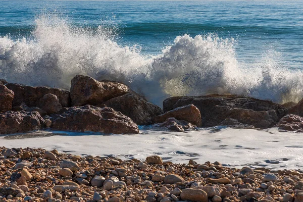 一个发泡的浪落在岸上的石头上 — 图库照片