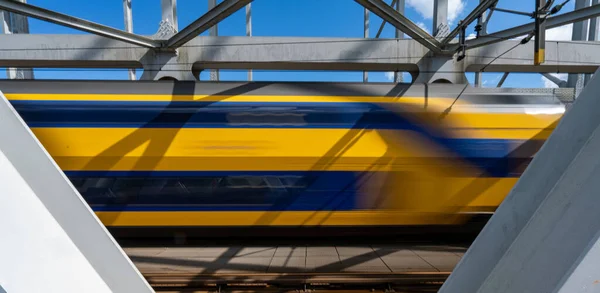 Närbild Stålkonstruktionen Järnvägsbro Med Stålbalkar Och Ett Korsande Tåg — Stockfoto