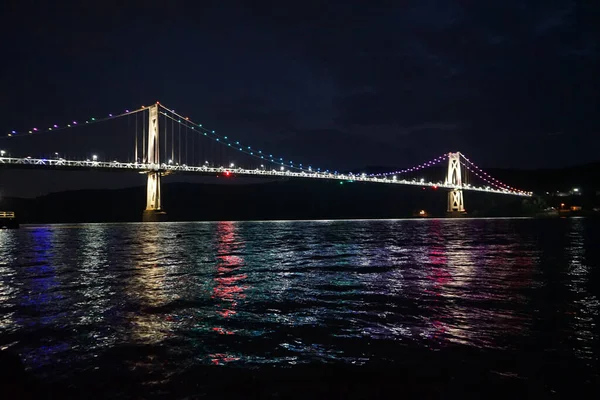 夜晚的悬索桥美丽的景色 水面上反射着五彩斑斓的灯光 — 图库照片