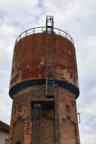 老旧水塔的垂直截图 顶部生锈 底部砖瓦生锈 — 图库照片