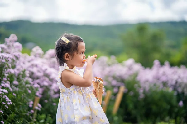 Little Girl Eating Ice Cream Beautiful Blossom Violet Margaret Flower — Stock Photo, Image