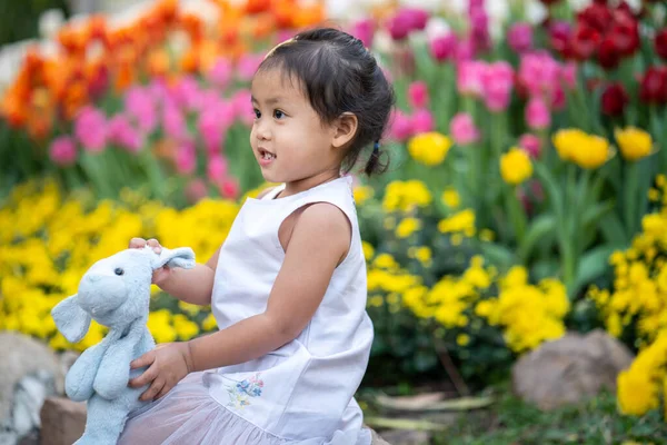 Cute Little Girl Sitting Flower Garden Holding Dog Doll — Stock Photo, Image