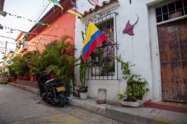 CARTAGENA, COLOMBIA - Jul 26, 2021: The Colombian flag hangs in a colorful alleyway in the Getsemani district of Cartagena, Colombia clipart