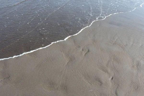 Una Spiaggia Sabbiosa Grigia Con Onda Oceanica Che Avvicina Una — Foto Stock