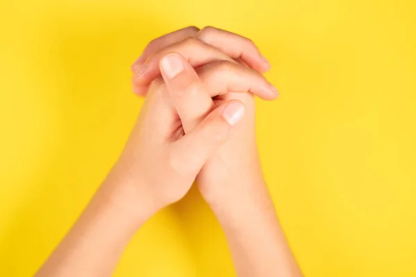 Tiro Vertical Das Mãos Entrelaçadas Uma Criança Fundo Amarelo — Fotografia de Stock