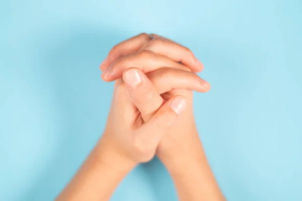 Uma Visão Superior Das Mãos Entrelaçadas Uma Criança Fundo Azul — Fotografia de Stock