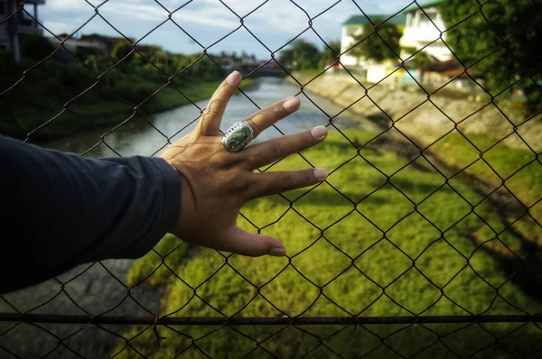 Mano Los Hombres Valla Metal Con Campo Hierba Borrosa Fondo — Foto de Stock