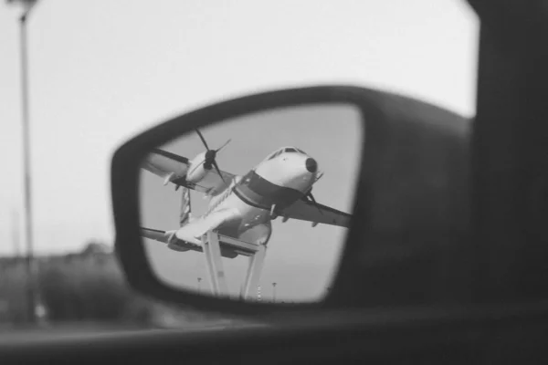反射镜飞机反射在汽车镜子上的黑白照片 — 图库照片