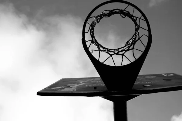 Eine Schwarz Weiß Aufnahme Eines Basketballnetzes Auf Wolkigem Hintergrund — Stockfoto