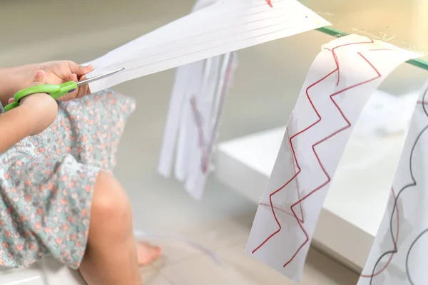 Una Niña Vestido Sentada Silla Cortando Papeles Con Rayas Geométricas — Foto de Stock