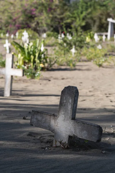 站在地下深处的一个十字架 旁边的坟场是模糊的背景 — 图库照片