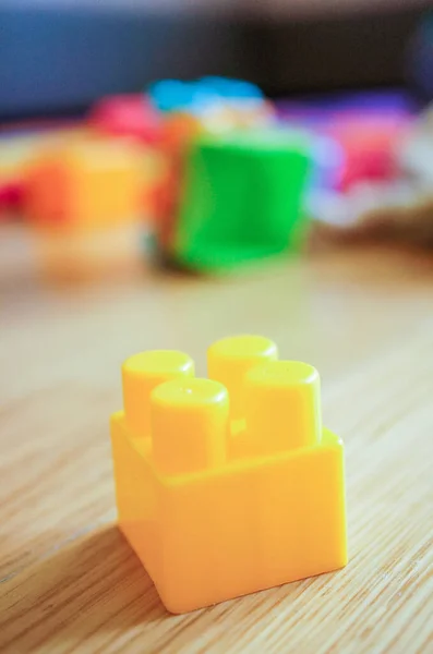 テーブルの上に黄色のおもちゃのプラスチック製のレンガ — ストック写真