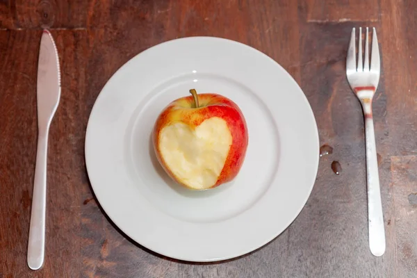 Górne Ujęcie Jabłka Wyrzeźbionym Sercem Białej Ceramicznej Płycie — Zdjęcie stockowe