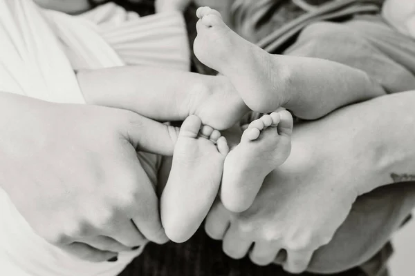 Uma Escala Cinza Dos Pés Gêmeos Nas Mãos Seus Pais — Fotografia de Stock