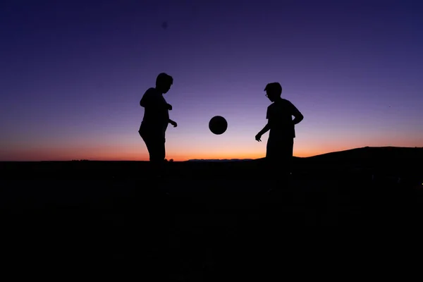 Vacker Bild Silhuetter Två Barn Som Leker Boll Solnedgången — Stockfoto