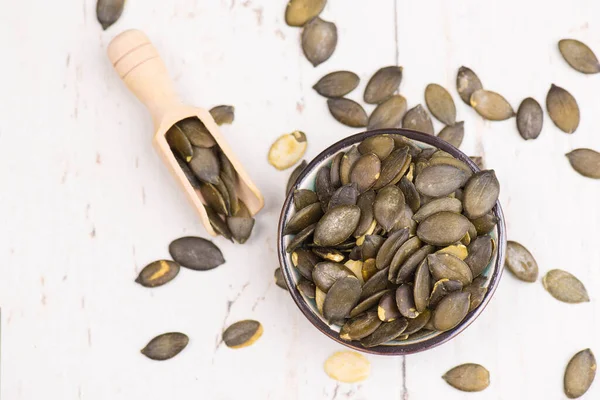 Top View Bowl Pumpkin Seeds Special Wooden Spoon White Surface — Stock Photo, Image