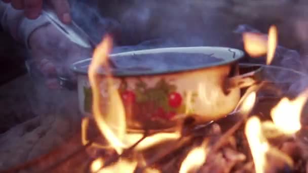 모닥불에서 음식을 준비하는 사람의 — 비디오